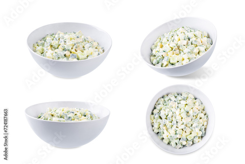 Egg cucumber avocado salad with mayonnaise sauce in a bowl on a white isolated background