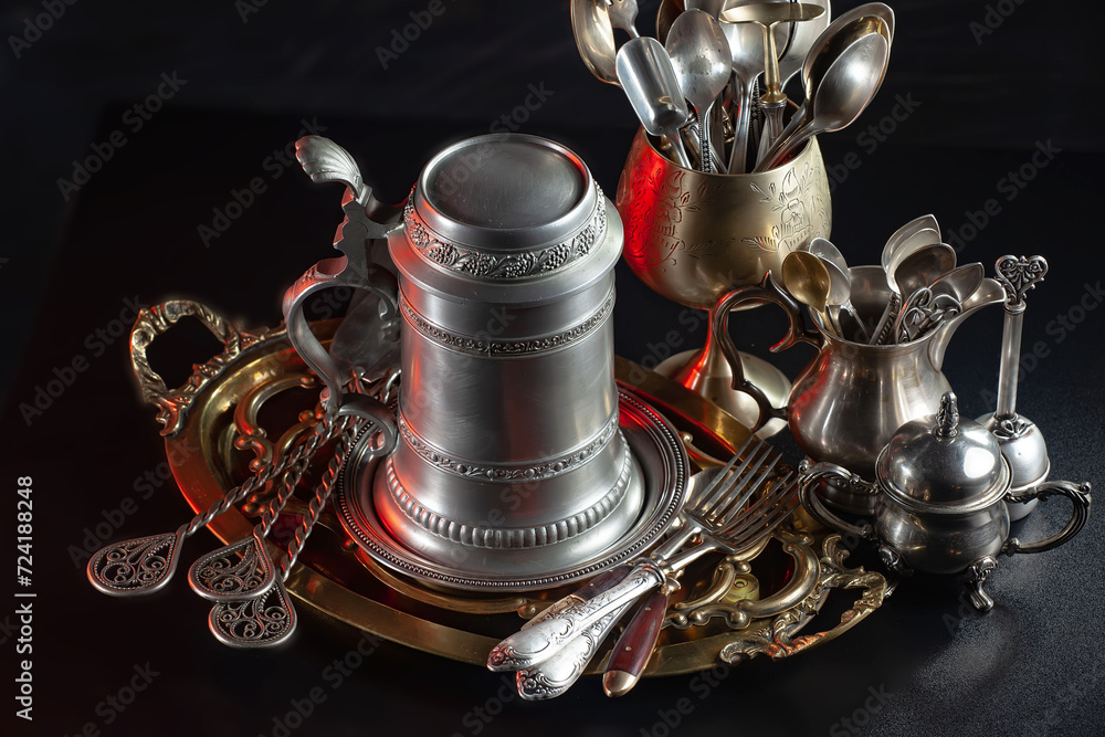 Antique silver cutlery, forks, spoons, knives, in a composition on a black background. Antique silver cutlery, forks, spoons, knives, in a composition on a black background.