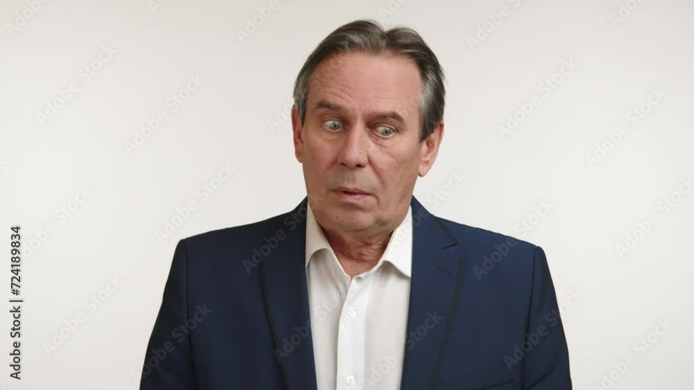 A mature businessman wearing a blue suit appears skeptical or uncertain, glancing sideways with a questioning look, potentially evaluating a situation or contemplating a decision. Camera 8K RAW. A mature businessman wearing a blue suit appears skeptical or uncertain, glancing sideways with a questioning look, potentially evaluating a situation or contemplating a decision. Camera 8K RAW.
