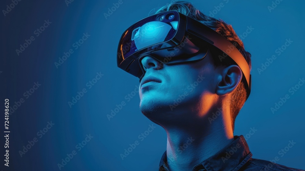 Portrait of a young man in virtual reality glasses. Studio shot blue backgroung Portrait of a young man in virtual reality glasses. Studio shot blue backgroung