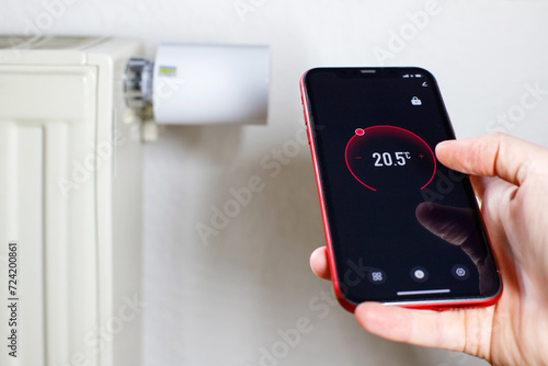 Controlling radiator heating temperature with a smart phone, close-up with radiator