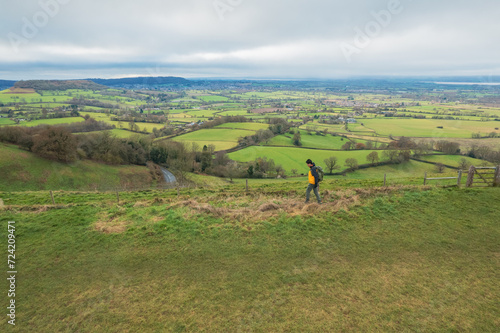 backpacker hiker on the high ground of Coaley Peak, Stroud, Gloucestershire, UK