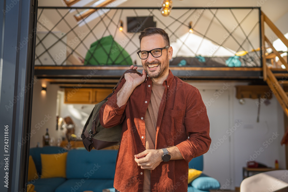 Fototapeta premium Portrait of one man happy caucasian male with travel bag at his house