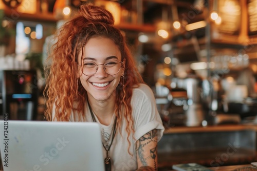 a smiling young person using a laptop