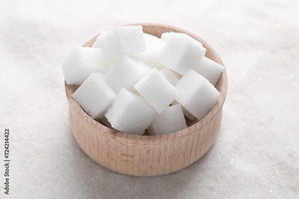 Different types of white sugar and bowl as background, closeup