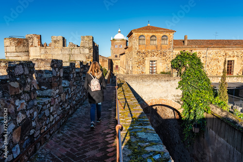 Tourist woman strolling over the wall of the medieval city of Caceres. photo