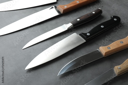 Many different knives on grey textured table
