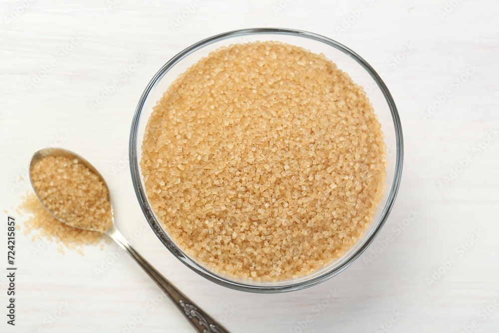 Brown sugar in bowl and spoon on white wooden table, flat lay Brown sugar in bowl and spoon on white wooden table, flat lay