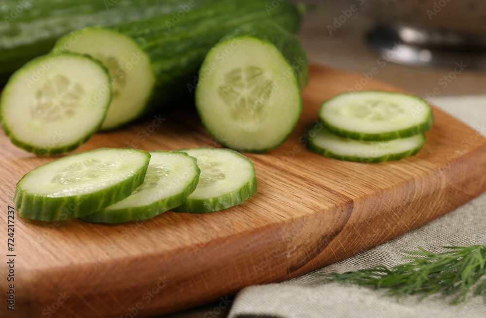 Cucumbers, cutting board and dill on table, closeup Cucumbers, cutting board and dill on table, closeup