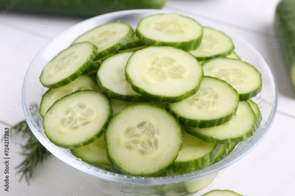 Cut cucumber in glass bowl on white table, closeup Cut cucumber in glass bowl on white table, closeup