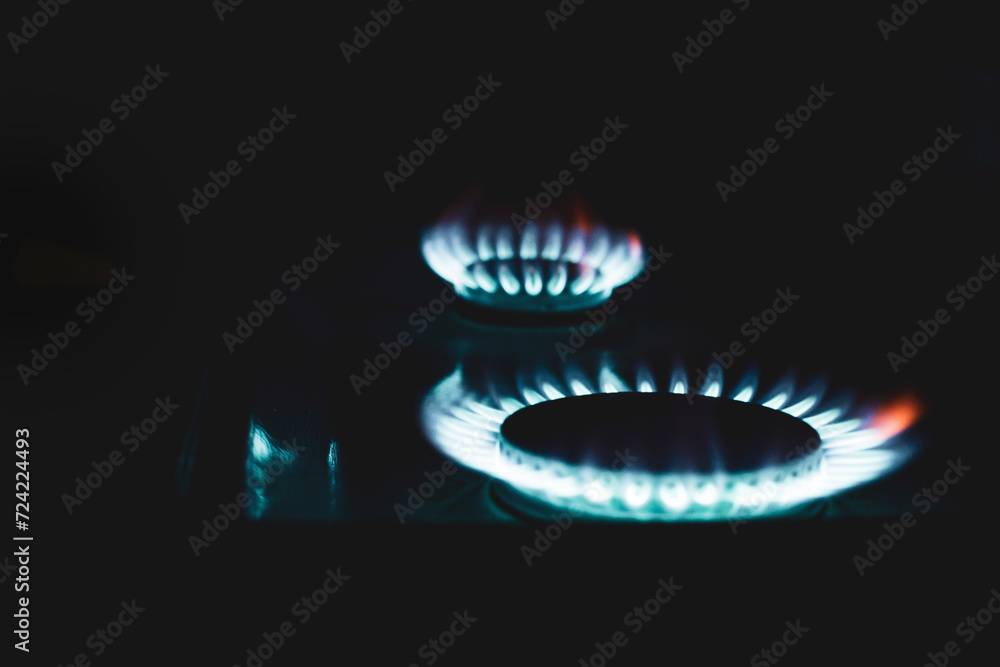 a hundred dollar bill on a gas burner with a burning fire on a black background, the front and back background is blurred with a bokeh effect a hundred dollar bill on a gas burner with a burning fire on a black background, the front and back background is blurred with a bokeh effect