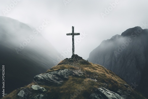 old solitary cross on a rock in a foggy gloomy mountain landscape