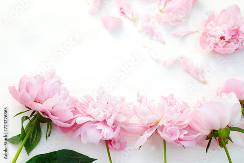 Fresh and lively, pink peonies create a vibrant spectacle on a white table, radiating the joy of spring. Top view with space for text.