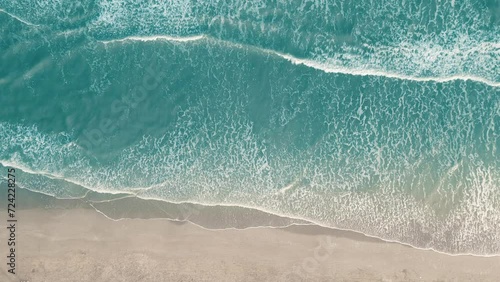 Drone aerial view of paradise beach. Turquoise sea water and clear sand at sunset.