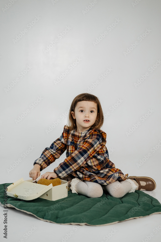 studio portrait of a little smiling girl lying on the floor and positively looking at the camera studio portrait of a little smiling girl lying on the floor and positively looking at the camera