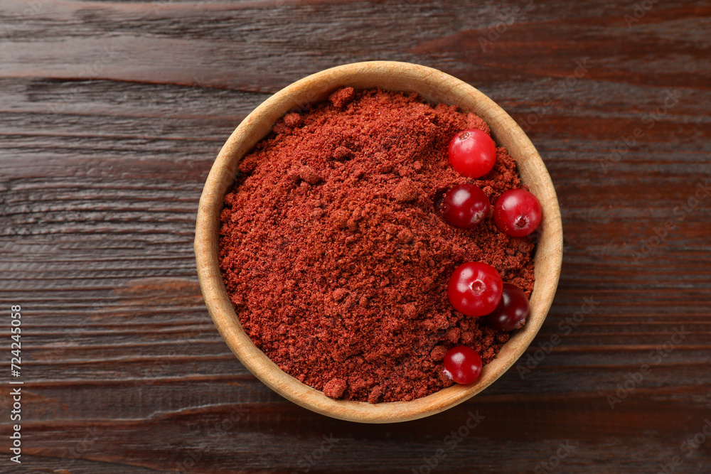 Dried cranberry powder and fresh berries in bowl on wooden table, top view Dried cranberry powder and fresh berries in bowl on wooden table, top view
