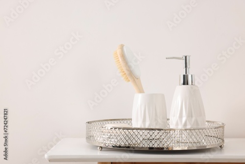 Different bath accessories and personal care products on table near white wall, space for text