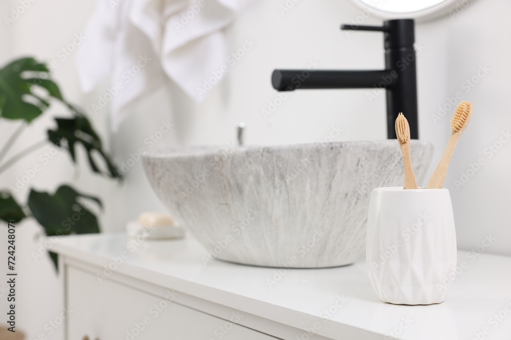 Bath accessory. Ceramic holder with toothbrushes on bathroom vanity indoors, space for text Bath accessory. Ceramic holder with toothbrushes on bathroom vanity indoors, space for text