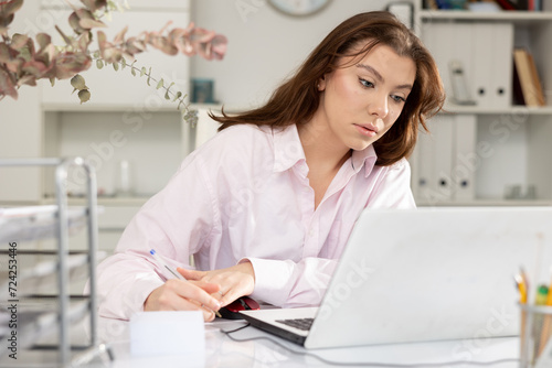 Successful adult business woman using laptop at workplace in office