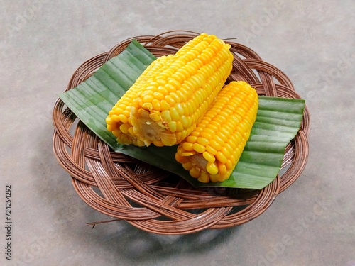 sweet corn (Zea mays Saccharata Sturt). Boiled sweet corn served on a wicker plate on a gray background. pile of sweet yellow fruit on a plate. tea time photo