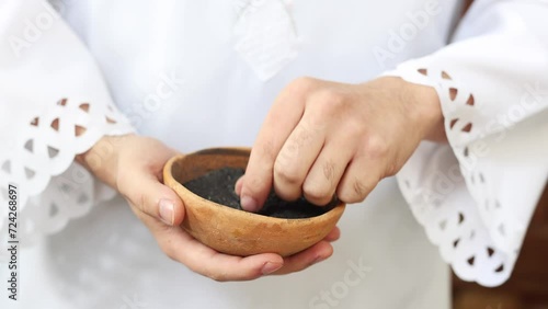 Priest holding a bowl of ashes during Ash Wednesday celebration.  photo