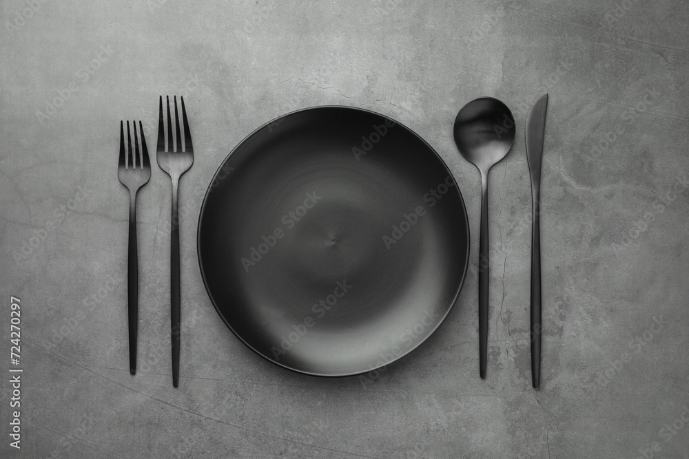 Empty plate and cutlery on grey table, flat lay Empty plate and cutlery on grey table, flat lay