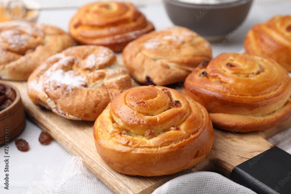 Delicious rolls with raisins and powdered sugar on table, closeup. Sweet buns Delicious rolls with raisins and powdered sugar on table, closeup. Sweet buns