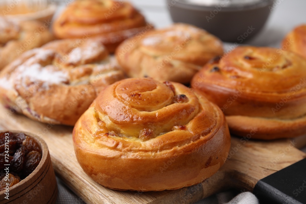Delicious rolls with raisins and powdered sugar on table, closeup. Sweet buns Delicious rolls with raisins and powdered sugar on table, closeup. Sweet buns