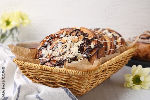 Delicious rolls with toppings and almond on white tiled table, closeup. Sweet buns