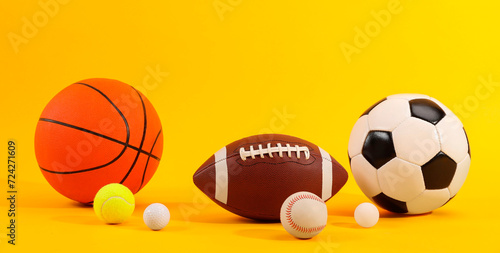 Many different sports balls on yellow background. Banner design