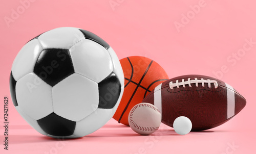 Many different sports balls on pink background