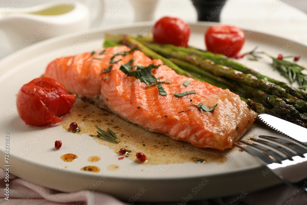 Tasty grilled salmon with tomatoes, asparagus and spices served on table, closeup Tasty grilled salmon with tomatoes, asparagus and spices served on table, closeup