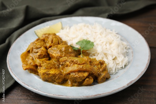 Delicious chicken curry with rice on wooden table, closeup