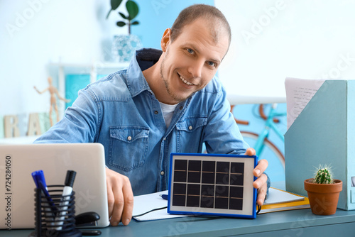 Young man charging laptop w...