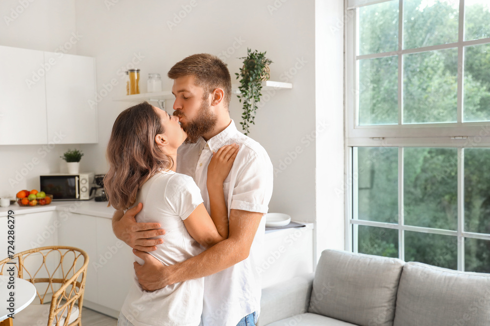 Happy couple in love hugging in kitchen Happy couple in love hugging in kitchen