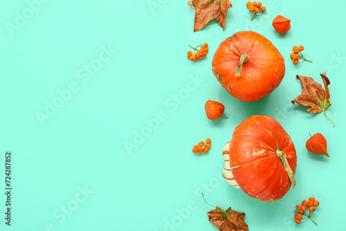Autumn composition with pumpkins, viburnum and leaves on turquoise background