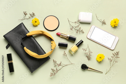 Composition with modern mobile phone, makeup products and beautiful flowers on beige background