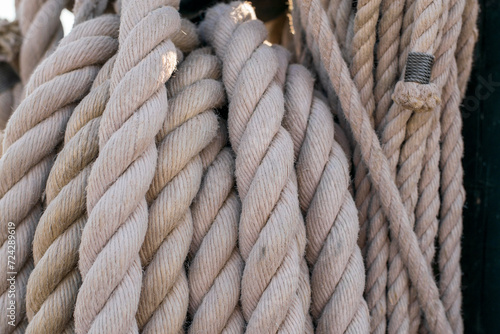 Close-up image showcases the complex texture and sturdy braiding of thick nautical ropes, reflecting a long-standing maritime heritage.