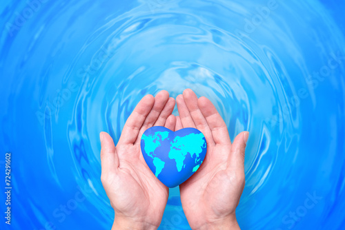 Two hands delicately hold a heart-shaped Earth in shades of blue, against a background that represents the rhythmic waves of water. The image celebrates World Water Day and the need to preserve water 
