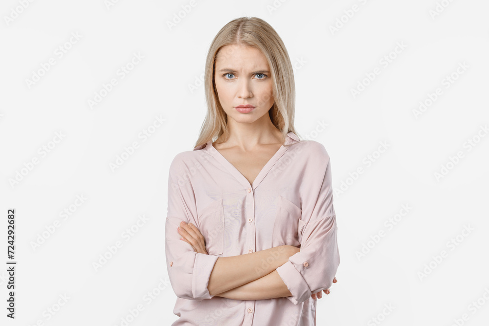 Portrait of angry woman standing with arms folded on white background. Negative emotion of sad disappointed furious female looking frowning in the camera Portrait of angry woman standing with arms folded on white background. Negative emotion of sad disappointed furious female looking frowning in the camera