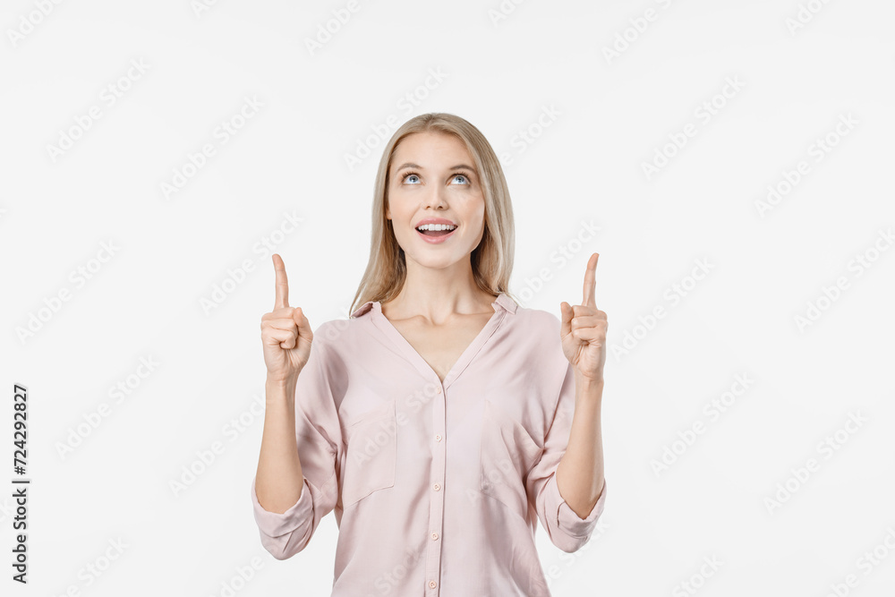 Young beautiful woman pointing over white background. Pretty female showing upwards with finger on free empty space for ad sale offer discount Young beautiful woman pointing over white background. Pretty female showing upwards with finger on free empty space for ad sale offer discount
