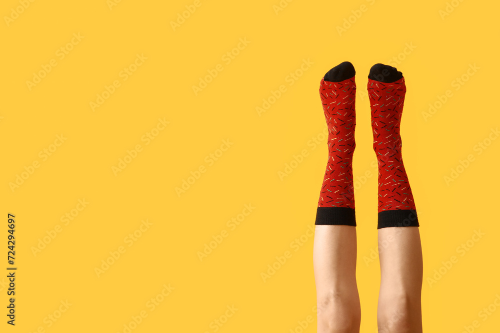Legs of young woman in red socks on yellow background Legs of young woman in red socks on yellow background