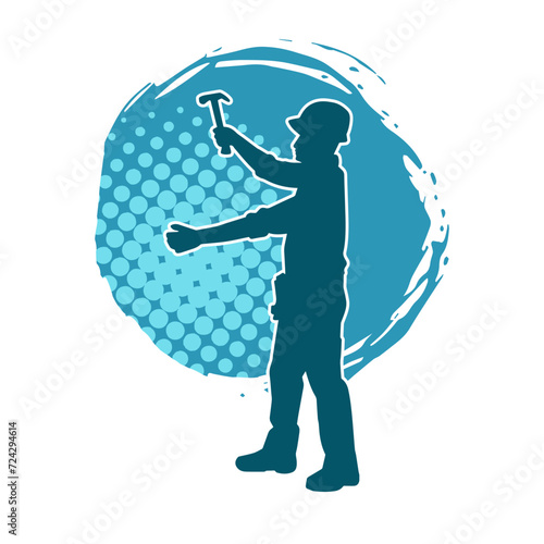 Silhouette of a worker carrying hammer tool. Silhouette of a worker in action pose using hammer tool.
