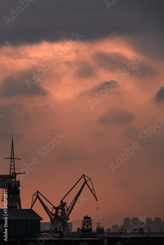 cranes at harbor at sunset, with beautiful cloud
