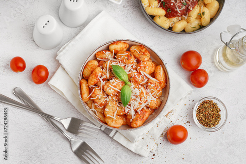 Bowls of tasty gnocchi with tomato sauce and cheese on white background photo