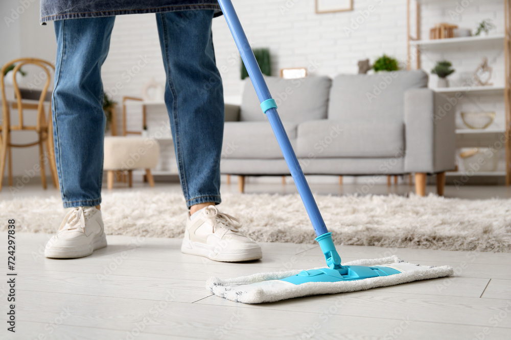 Fototapeta premium Woman mopping floor in living room