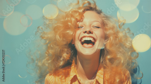 Blissful young blonde with curly hair laughing against a blue sky with light bokeh.
