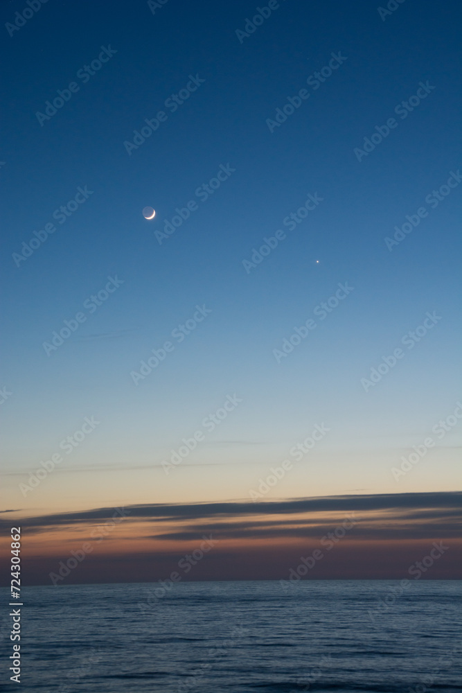 静かな海の夕暮れと三日月と金星
