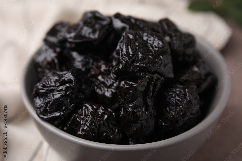 Sweet dried prunes in bowl on table, closeup Sweet dried prunes in bowl on table, closeup