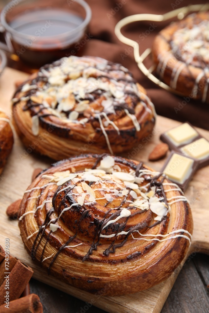 Delicious rolls with toppings and nuts on wooden table, closeup. Sweet buns Delicious rolls with toppings and nuts on wooden table, closeup. Sweet buns